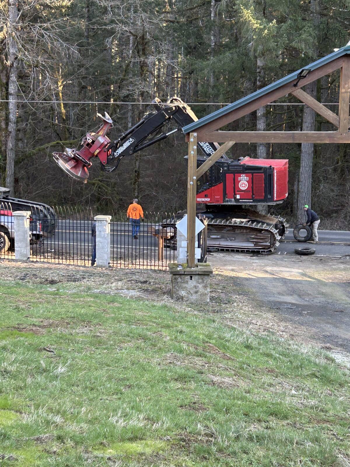 Feller-buncher arriving past the intact gate