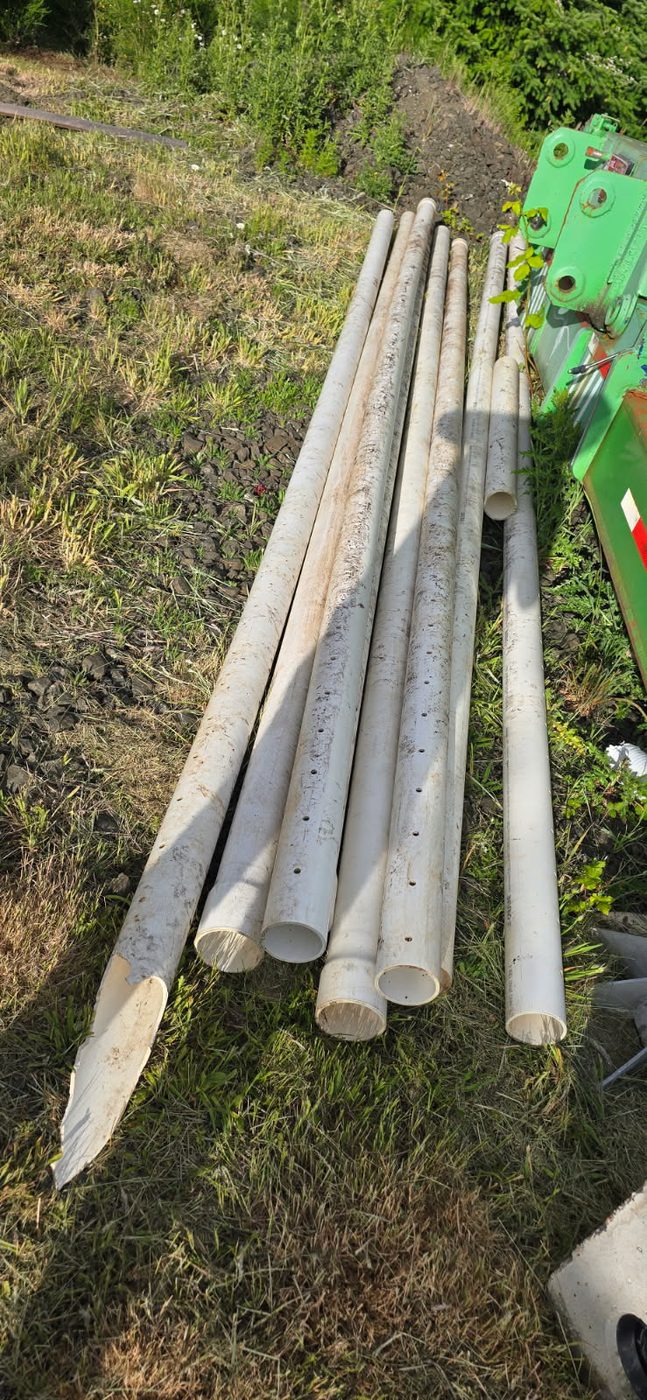 PVC pipe staged on site, including lengths of perforated drainfield distribution pipe, May 30, 2026